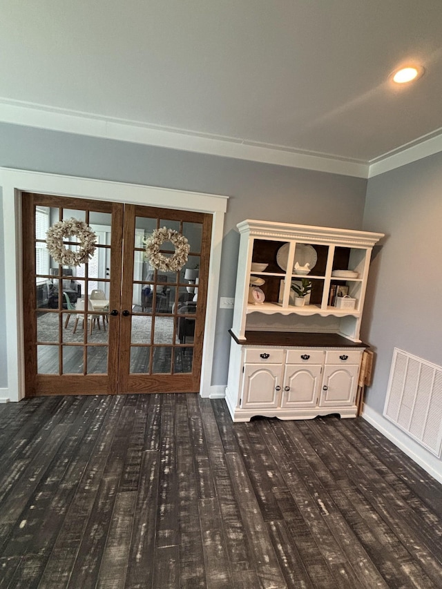 unfurnished dining area with ornamental molding, french doors, baseboards, and dark wood-style floors