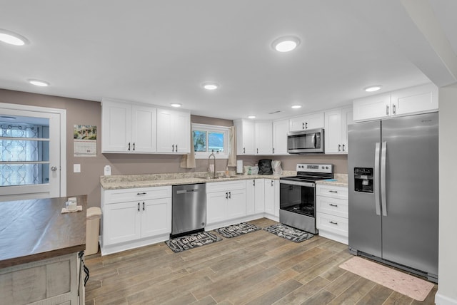 74 Farmer Rd, Crossville, TN 38571 - kitchen with white cabinetry, light wood-style flooring, a sink, stainless steel appliances, and recessed lighting