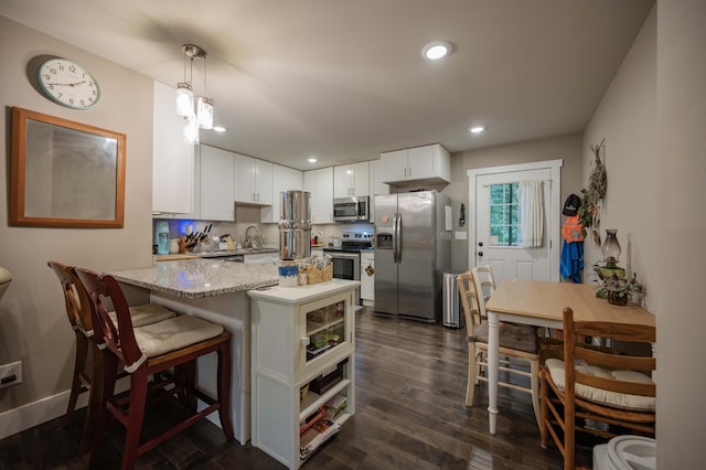 675 Hog Back Ridge Rd, Bethpage, TN 37022 - kitchen with stainless steel appliances, a peninsula, white cabinets, dark wood finished floors, and recessed lighting