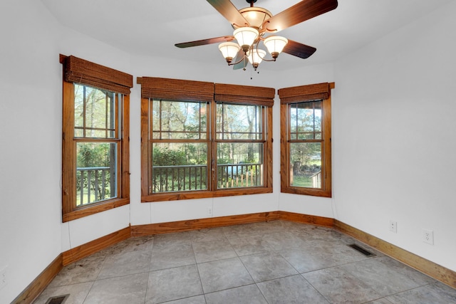 spare room with baseboards, visible vents, and ceiling fan