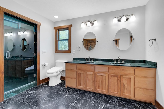 bathroom with baseboards, marble finish floor, toilet, and a sink