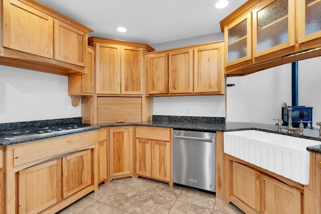 kitchen with a wood stove, recessed lighting, a sink, stainless steel appliances, and light tile patterned flooring