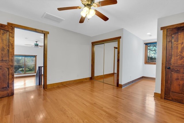 interior space featuring light wood finished floors, a ceiling fan, visible vents, and baseboards