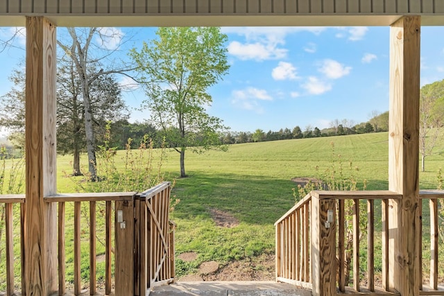 wooden deck with a lawn and a rural view