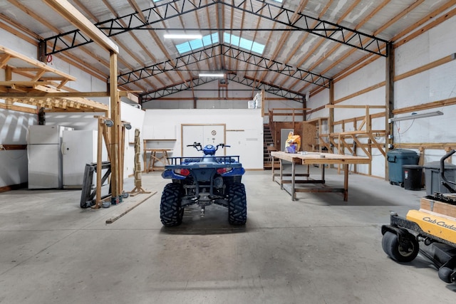 garage with a workshop area and freestanding refrigerator