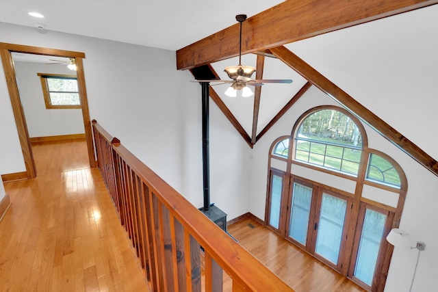 corridor with an upstairs landing, lofted ceiling with beams, baseboards, light wood-type flooring, and recessed lighting