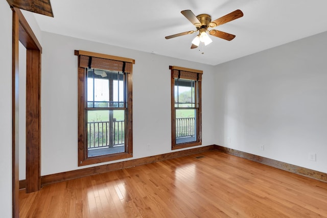 unfurnished room with baseboards, wood finished floors, and a ceiling fan