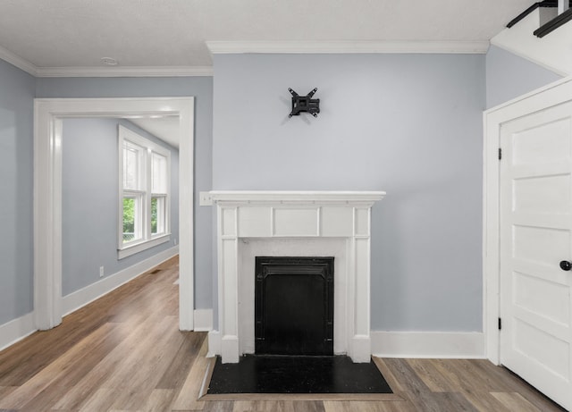 room details with ornamental molding, a fireplace with flush hearth, wood finished floors, and baseboards