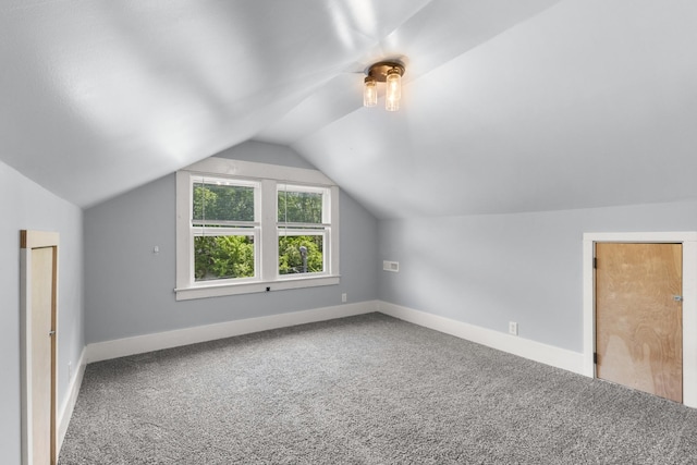 additional living space featuring carpet flooring, vaulted ceiling, and baseboards