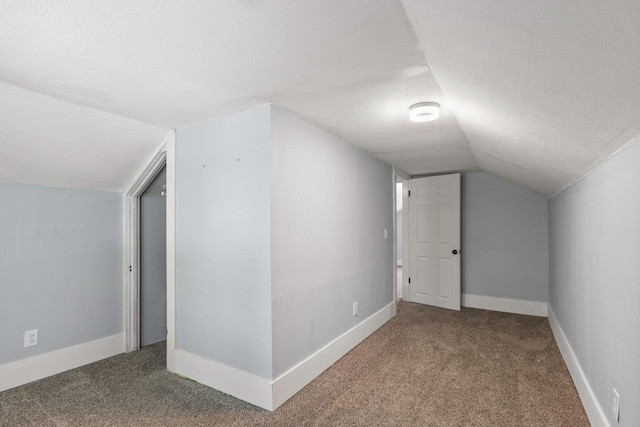 additional living space featuring baseboards, carpet floors, and vaulted ceiling