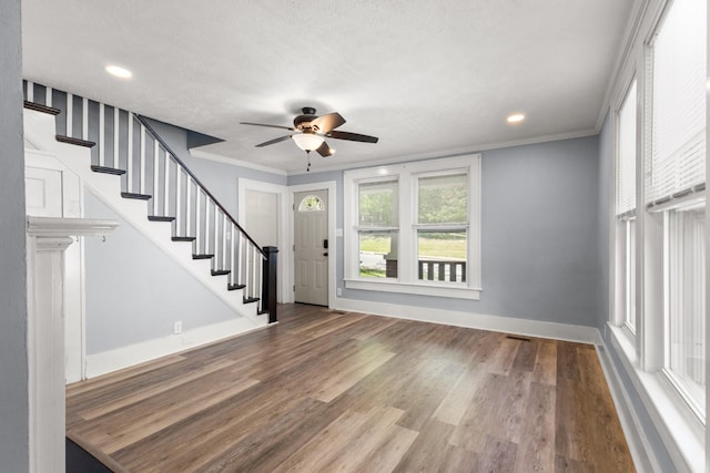 interior space with crown molding, ceiling fan, stairway, and wood finished floors