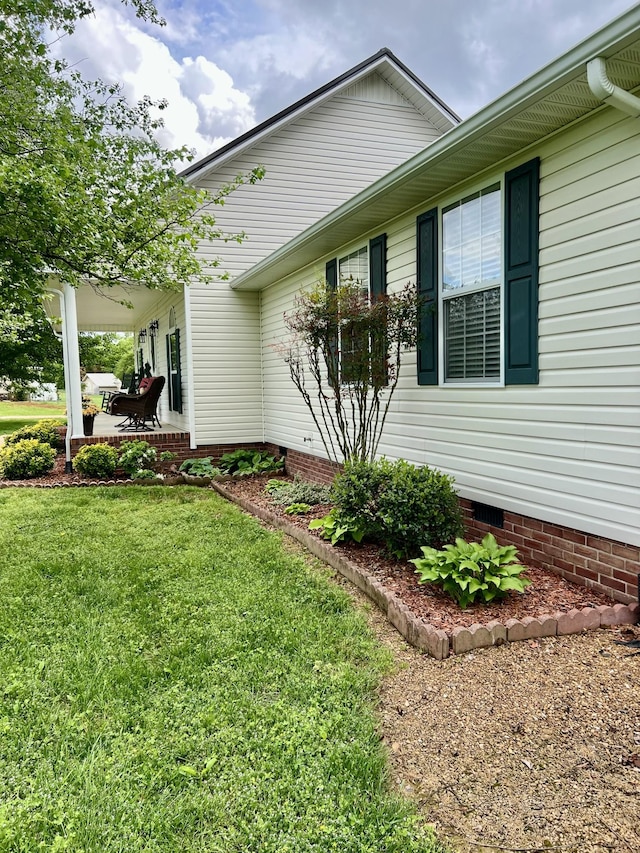 view of property exterior with a lawn and crawl space