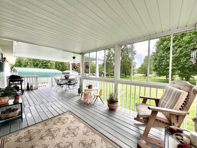 sunroom / solarium with outdoor dining area and a wealth of natural light