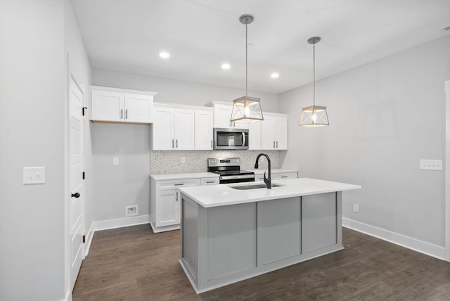 kitchen with tasteful backsplash, a sink, stainless steel appliances, light countertops, and an island with sink