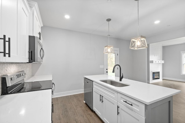 kitchen featuring tasteful backsplash, stainless steel appliances, light countertops, and a sink