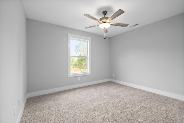 carpeted empty room with a ceiling fan, visible vents, and baseboards