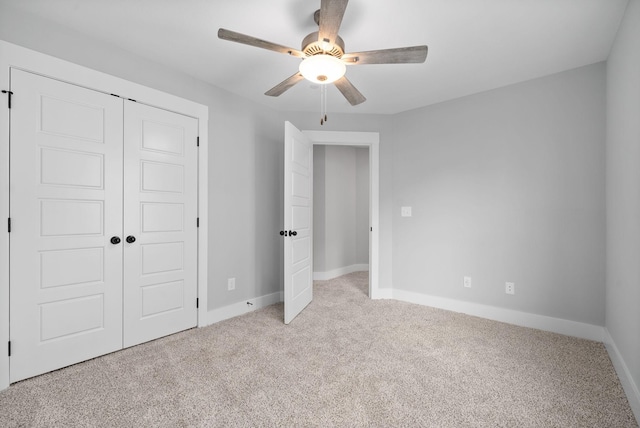 unfurnished bedroom with a closet, ceiling fan, carpet floors, and baseboards
