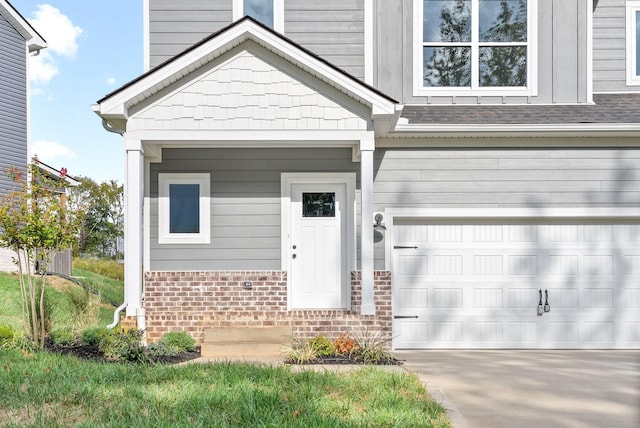 property entrance with brick siding, a shingled roof, concrete driveway, and an attached garage