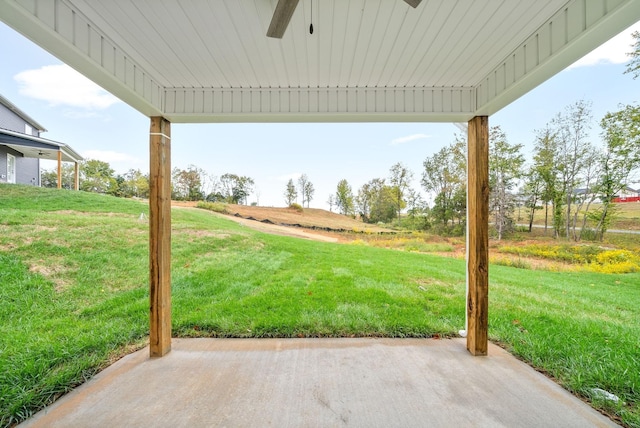 view of yard featuring a patio, ceiling fan, and a rural view