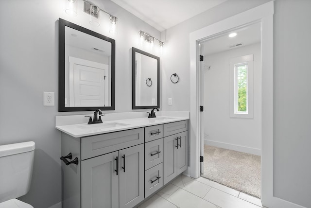 full bathroom featuring double vanity, visible vents, toilet, and a sink