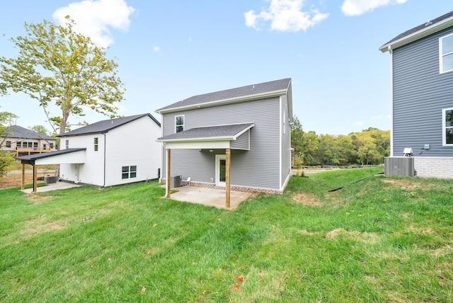 rear view of house featuring a lawn, a patio area, and central AC unit