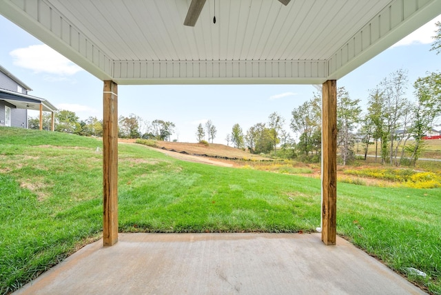 view of yard featuring a rural view, a ceiling fan, and a patio area