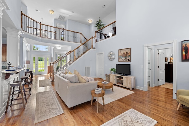 1004 Sattui Ct, Franklin, TN 37064 - living room featuring french doors, a high ceiling, visible vents, light wood-style floors, and stairs