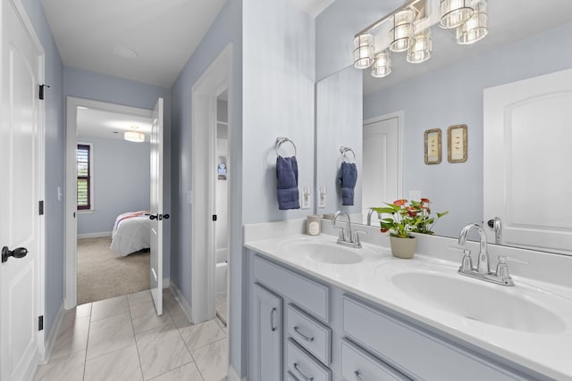 1004 Sattui Ct, Franklin, TN 37064 - bathroom featuring double vanity, baseboards, marble look tile flooring, and connected bathroom