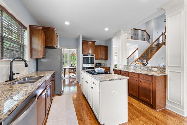 1004 Sattui Ct, Franklin, TN 37064 - kitchen featuring a sink, light wood finished floors, stainless steel appliances, and a center island