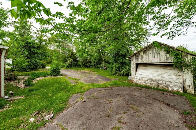 view of yard featuring a detached garage and an outbuilding