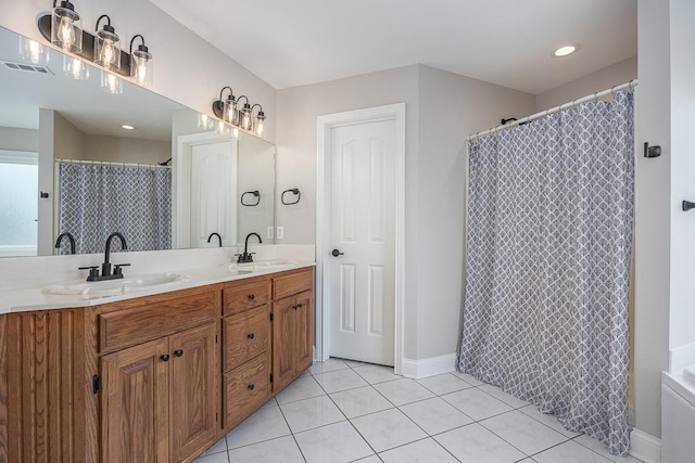 full bath with visible vents, a sink, baseboards, and tile patterned flooring