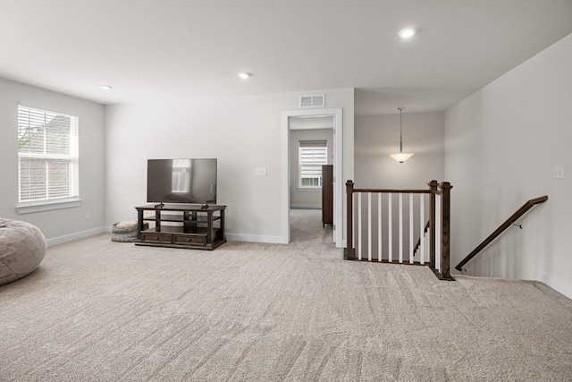 carpeted living area with visible vents, recessed lighting, baseboards, and a wealth of natural light