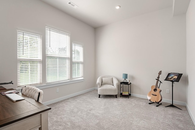 sitting room with visible vents, baseboards, and light carpet
