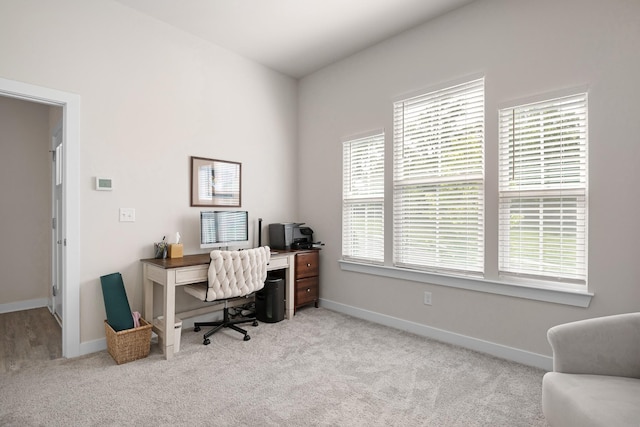 office area with baseboards and light carpet