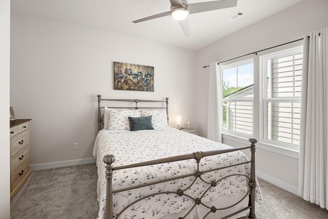 bedroom with baseboards, light colored carpet, and visible vents