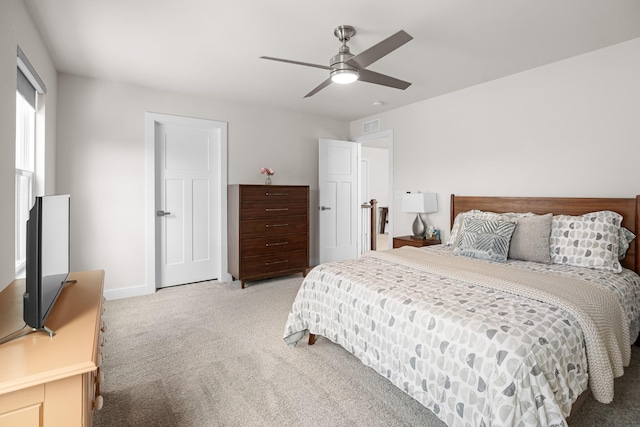 bedroom featuring ceiling fan, visible vents, light carpet, and baseboards