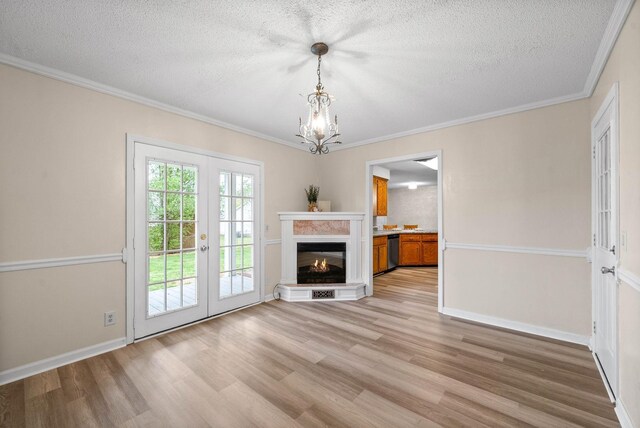 3844 Marla Cir, Clarksville, TN 37042 - unfurnished living room with a textured ceiling, light wood-style floors, a chandelier, baseboards, and french doors