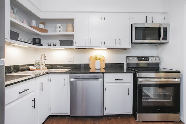 3901 Whitland Ave # 11, Nashville, TN 37205 - kitchen with dark stone countertops, stainless steel appliances, white cabinets, a sink, and dark wood-style floors