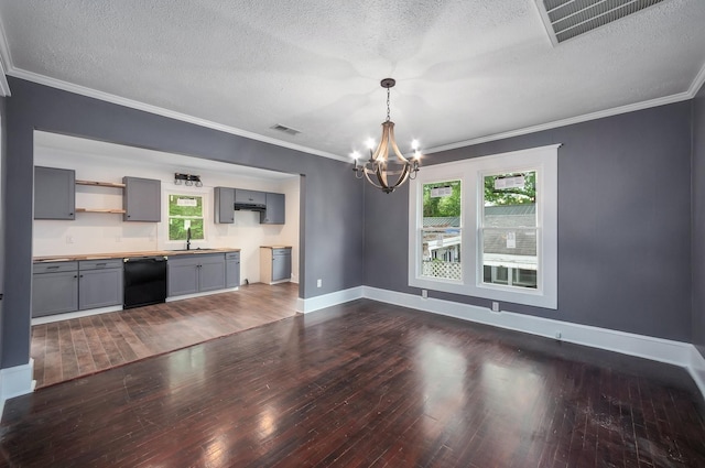 unfurnished living room featuring a notable chandelier, a sink, dark wood-style flooring, and visible vents