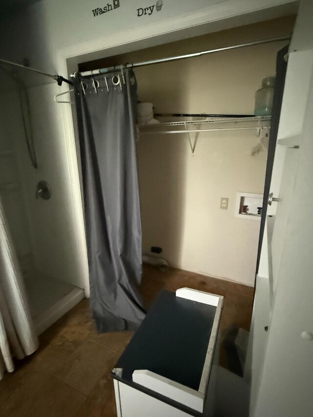 interior space with a shower with curtain and tile patterned flooring