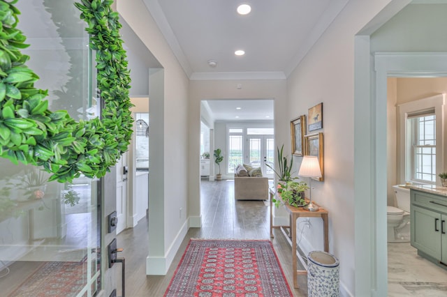 entryway with crown molding, light wood-style flooring, recessed lighting, and baseboards