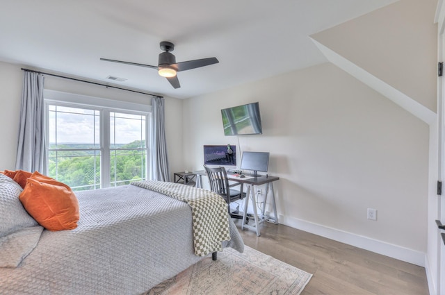 bedroom featuring visible vents, a ceiling fan, light wood finished floors, and baseboards