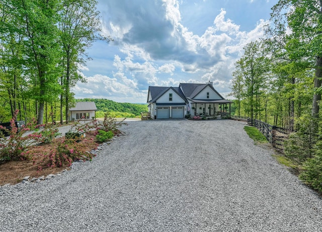 view of front facade featuring driveway, an attached garage, and fence