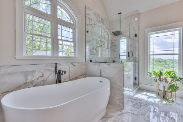 full bathroom with a soaking tub, a stall shower, marble finish floor, and vaulted ceiling