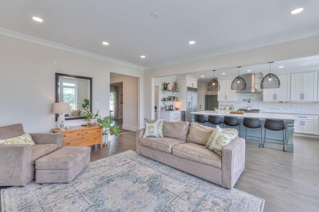 living room featuring recessed lighting, crown molding, and light wood-style flooring