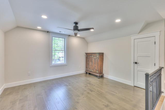 bonus room featuring a ceiling fan, baseboards, vaulted ceiling, and light wood-style floors