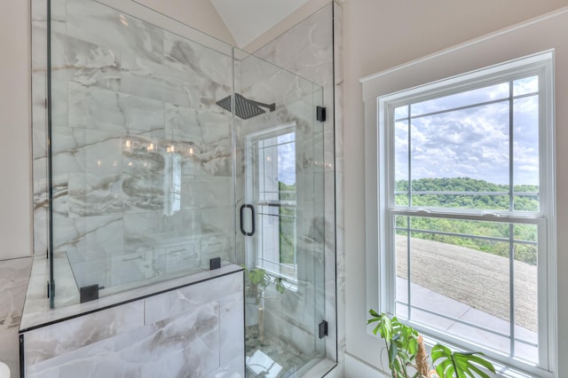 bathroom featuring a marble finish shower and vaulted ceiling