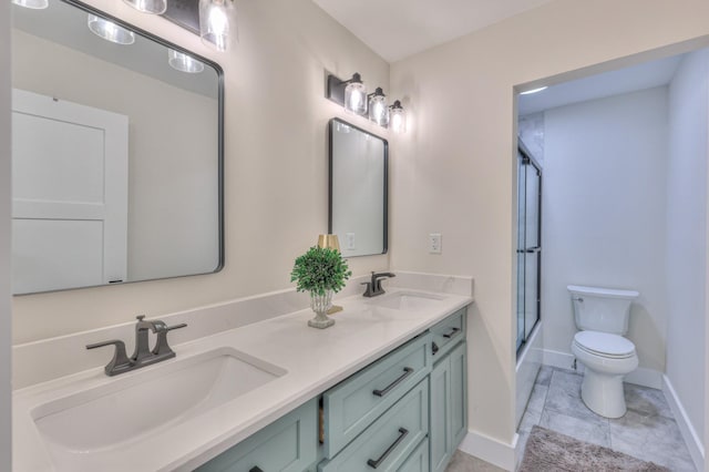 full bath featuring baseboards, toilet, double vanity, and a sink