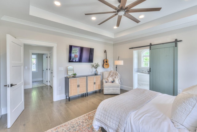 bedroom featuring a barn door, recessed lighting, and baseboards
