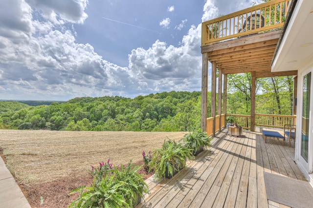 wooden terrace featuring a view of trees